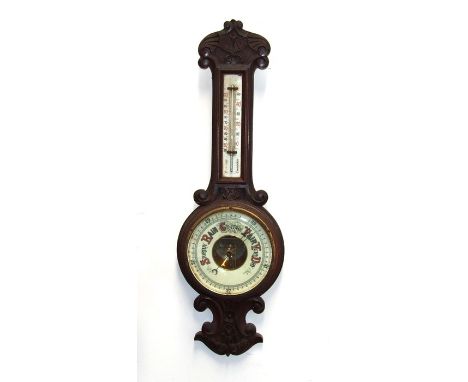 An Edwardian barometer and thermometer in a carved oak case, 80cms (31.5ins) high.