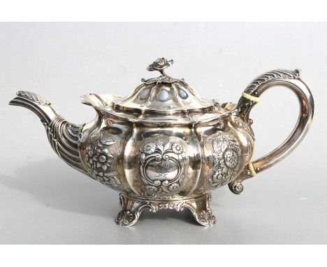 A George III silver teapot of compressed circular form with repousse rose decoration, crested and with a cast rose finial, Lo