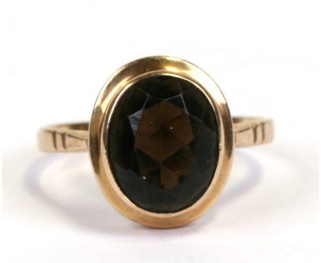 A 9ct gold ring set with an oval smoky quartz, approx UK size 'K'.