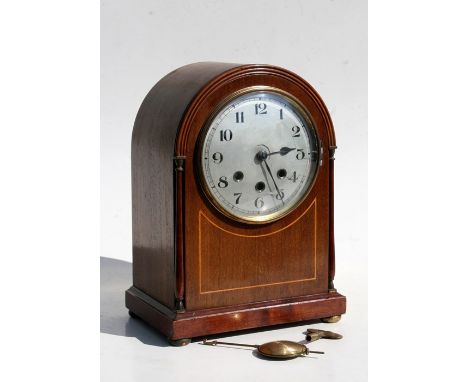 An Edwardian musical mantle clock with silvered dial and Arabic numerals in a dome topped mahogany case with boxwood stringin