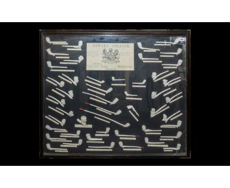 A Large Glazed Wall Display containing approx 47 clay pipes. All numbered and described with central advertising plaque for E