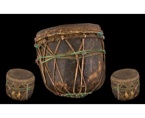 Tribal Antique Wood Drum hewn form a tree trunk with a skin applied. Decorated in string cords. 10 inches high and 10 inches 