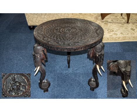 Indian Carved Round Teak Centre Table with carved top of typical form, supported by elephant trunk legs. Circa 1900. 26 inche