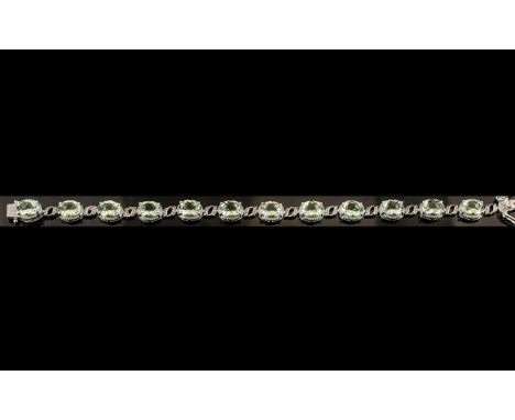 Green Amethyst Tennis Bracelet, 12 oval cut sparkling green amethysts, totalling 20cts, set in a line, interspaced with millg