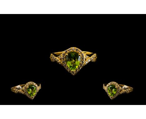 Peridot Pear Shaped Halo Ring, a pear cut, bright, clear peridot of 1.65cts set within a halo of white zircons, which continu