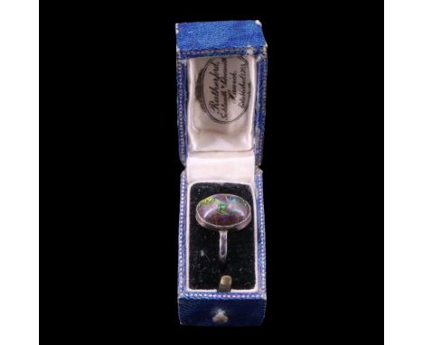 A black opal ring, being an oval cabochon of approx 14 mm x 10 mm, bezel-set on yellow metal, O/P, 3.3 g