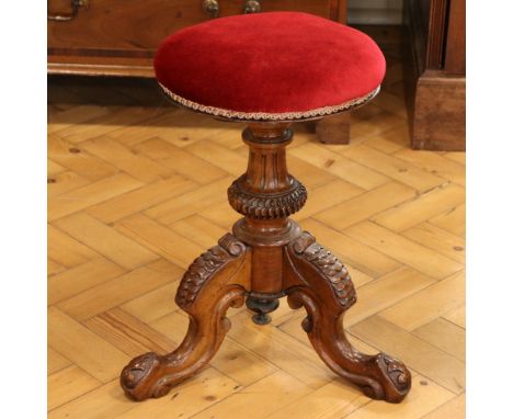 A Victorian carved walnut tripod piano stool