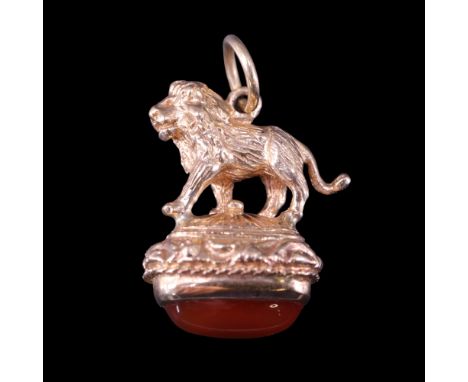 A 9 ct gold mounted carnelian fob, the cushion-shaped cabochon bezel-set and surmounted by a lion, 22 mm excluding suspender 