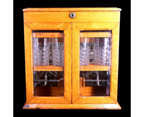 A Victorian oak combined humidor, tantalus and drinks cabinet, having a hinged lid with a Bramah patent lock and a pair of be