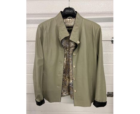 A pale sage green soft leather jacket by Alji Piel. Button front with front slant pockets and turn back cuffs. Floral and leo