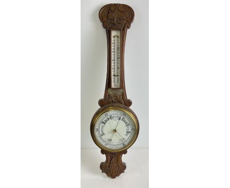 A 1920's oak cased banjo barometer with integral thermometer. Carved detail to case and engraved presentation plaque dated 19