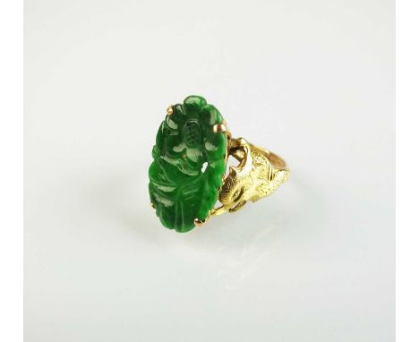 A 14ct gold jade ring, designed as a carved oval jade plaque claw set in yellow gold to decorative stylised dragon shoulders,