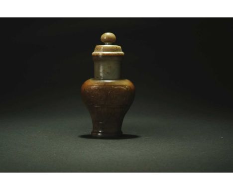 A Chinese green and russet jade archaistic vase and cover, Qing DynastyOf compressed baluster form, the body carved with taot