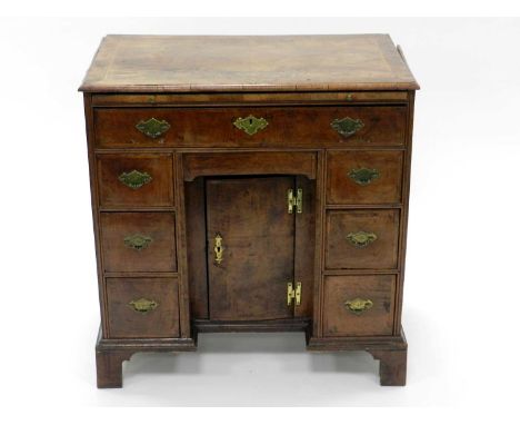 A George II walnut veneered dressing chest, the rectangular top 1/4 veneered and inlaid with feather banding above a brushing