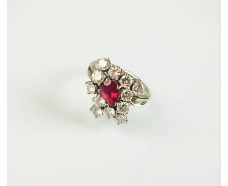 A ruby and diamond dress ring, designed as a central pear cut ruby claw set within an abstract surround of twelve brilliant c