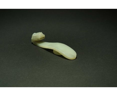 A Chinese pale green jade belt hook, Qing Dynasty, 19th centuryWith a curving shaft terminating in a dragon head hook, the un