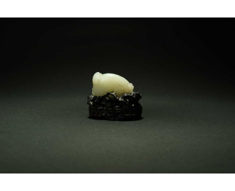 A Chinese pale green and russet jade carving of an aubergine, 18th/19th centuryThe plump fruit issuing trailing foliage and w