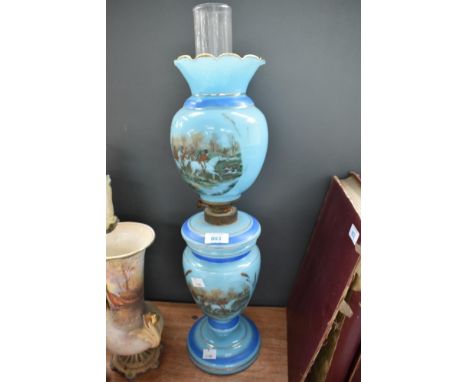 A Victorian blue opaline oil lamp having hunting pictoral decoration. Crack to top shade.