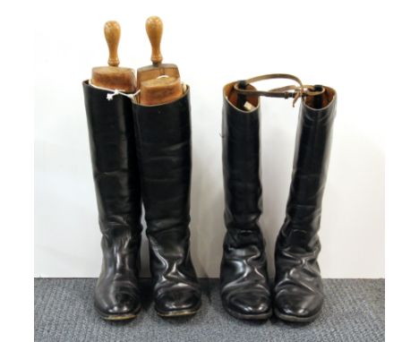Two pairs of vintage leather riding boots, with one pair of wooden boot jacks.