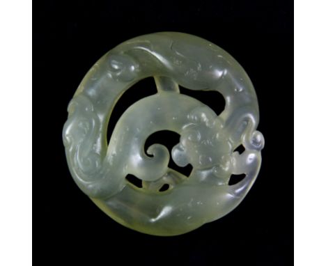 A Chinese carved translucent celadon green nephrite jade amulet of a coiled dragon, Dia. 5cm, probably early 20th century.