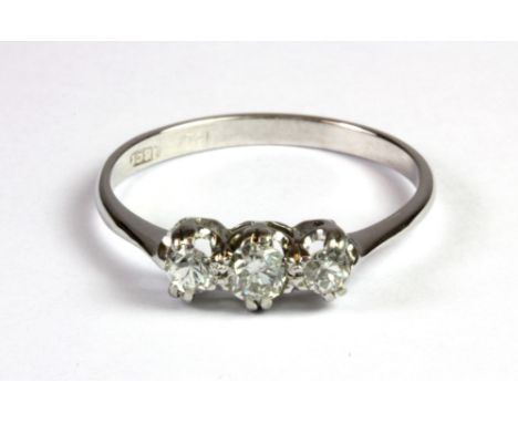 An 18ct white gold and platinum (stamped 18ct and plat) three diamond set ring (R).