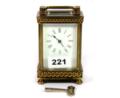A late 19th / early 20th century brass and four glass carriage clock, with applied rope twist style decoration, raised on fou