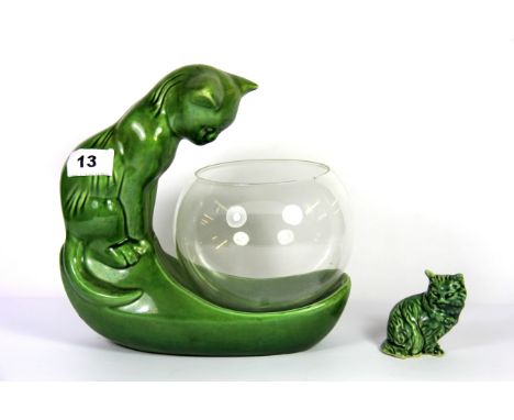 A green glazed pottery model of a cat peering into a glass bowl together with a small green pottery cat, H. 22cm.