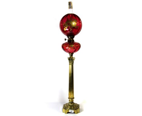 A superb 19th century brass column oil lamp with cranberry shade and well, the shade decorated with a Chinese style dragon an