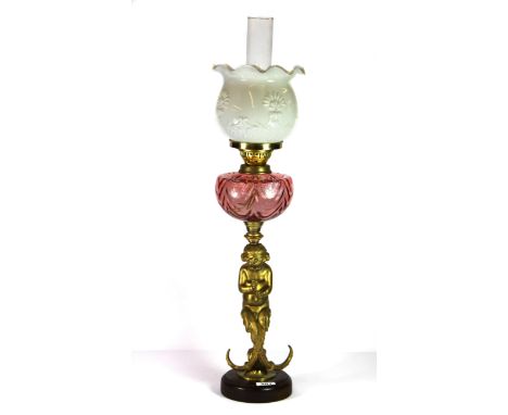 A 19th century gilt brass oil lamp with tinted glass bowl and relief decorated milk glass shade, H. 76cm.