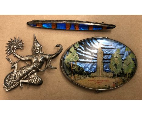 SIAM DANCING FIGURE BROOCH, EMPIRE EXHIBITION 1938 LUSTRE OVAL COMPACT AND A FOIL ELONGATED BAR BROOCH
