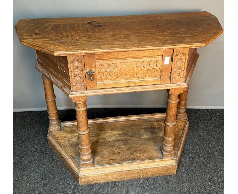 Antique light oak church style console, the shaped top above a single cabinet leading to interior storage, raised by four tur