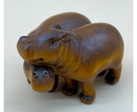 Japanese hand carved netsuke sculpture of a pair of hippos, both have black bead eyes and signed by the artist. [5.2cm in len