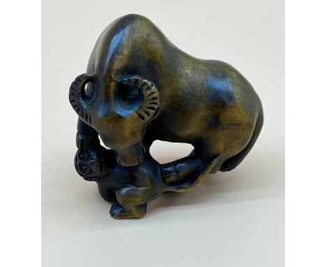 Japanese hand carved netsuke sculpture of an Ox standing on a monkey. Signed. [4.5cm high] 
