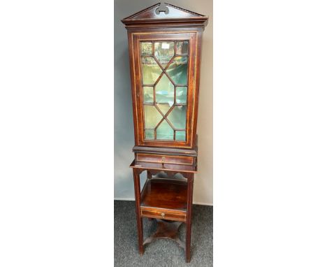 19th century two section display cabinet, the carved triangular top above a single moulded and glass door leading to shelved 