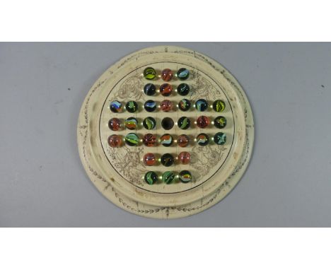 A Reproduction Ivorine Solitaire Board with Scrimshaw Decoration Containing a Selection of Vintage and Modern Marbles, 23cm D