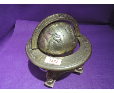 A heavy brass cast model of a globe with zodiac references
