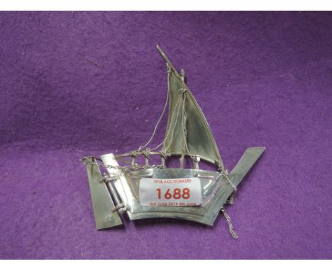 A white metal model of a sailing junk stamped S925