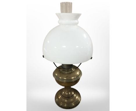 A brass oil lamp with opaque glass shade, height 52 cm.