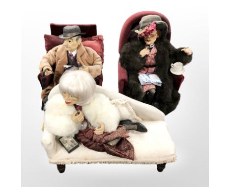 Three vintage dolls, seated on armchairs and a chaise longue, largest 43 cm wide.