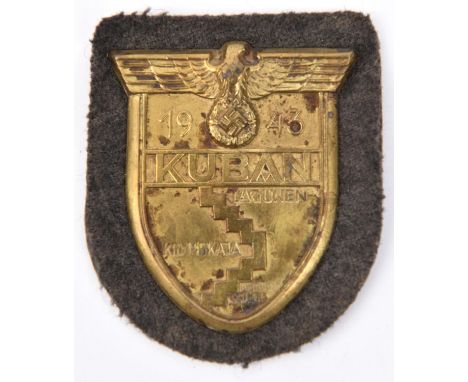 A Third Reich brass Kuban shield,  on field grey cloth patch with paper backing. GC 