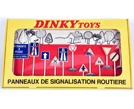 An original French Dinky Toys Traffic Signs set (593). 12 plastic road signs with metal bases, all still fixed into the red c