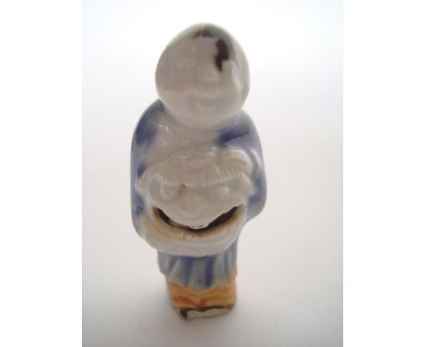 A 19th Century Japanese Hirado porcelain netsuke, moulded as a figure holding a Karashishi mark for lion dance, carved with a