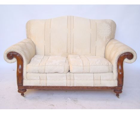 A two seater carved mahogany framed sofa with scroll arms and hump back. 