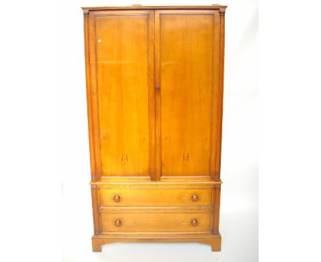 A 20th Century cherry wardrobe, the upper section with a pair of panelled cupboard doors, enclosing hanging space over two lo