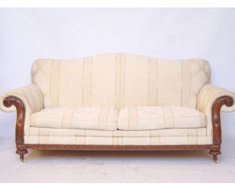 A three seater carved mahogany framed sofa with scroll arms and hump back. 