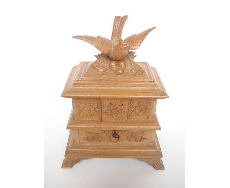 A late 19th Century Black Forest carved jewellery box, the hinged lid surmounted with a carved grouse with spreading wings, o