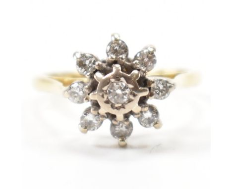 A hallmarked 18k gold &amp; diamond cluster ring. Having a central bezel set diamond surrounded by further cathedral set diam