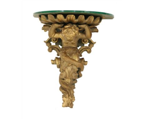 A carved wooden and composite wall bracket, 18th century style, in the form of a cherub holding a shell above his head, with 