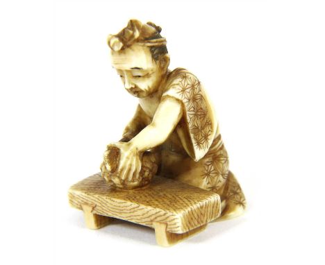 A Japanese carved ivory netsuke, Meiji period, of a man chopping gourds, bearing a red lacquer seal to base, 3.5cm high