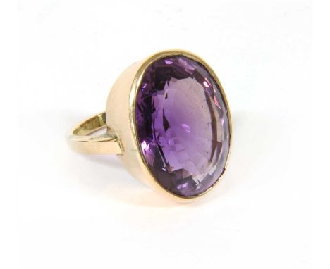 A single stone amethyst ring, with an oval mixed cut amethyst, rub set to a plain collet, tested as approximately 9ct gold, s